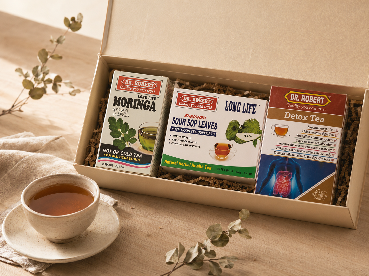 Editorial view of the Alma Tea Discovery Trio with moringa, soursop leaves and detox teas beside a ceramic cup.